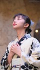 A woman in a kimono is looking up at the sky.