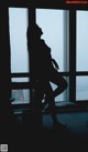 silhouette of woman standing in front of window