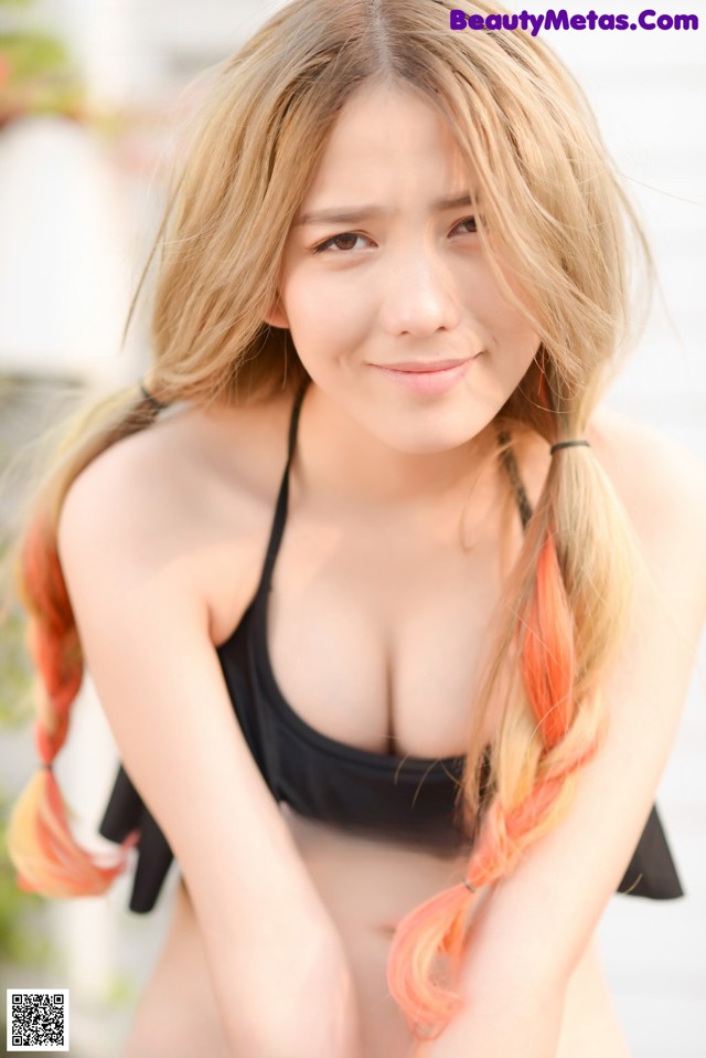 A woman in a black bikini posing for a picture.