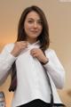 A woman in a white shirt and a red and black tie.