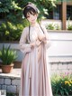 A woman in a pink kimono is posing for the camera.