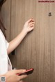 A woman using a smart phone to unlock a door.