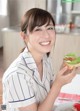 A woman sitting at a table with a plate of food.