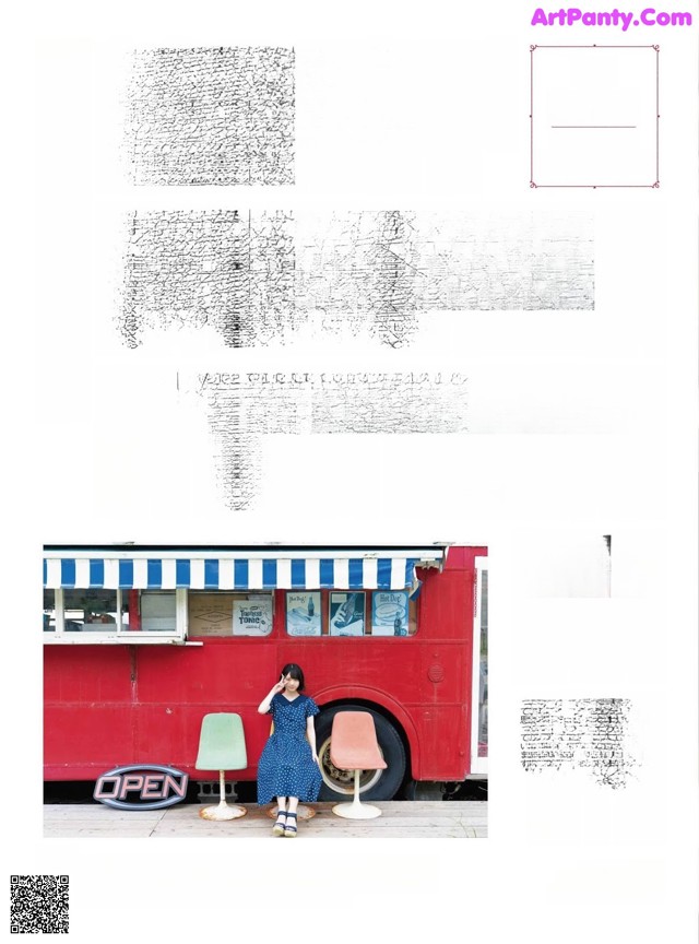 A woman sitting on a stool in front of a red bus.