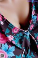 A close up of a woman wearing a dress with flowers on it.