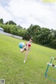 A woman kicking a soccer ball in a field.