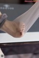 A close up of a person's foot with a pair of sheer stockings.